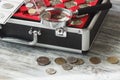 Different collector`s coins in the box with a magnifying glass