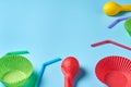 Different color paper molds for baking muffins, balloon and straw scattered on blue desk on kitchen