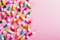 Different color pills on pink background Royalty Free Stock Photo