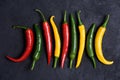 Different colored chili pepper on dark stone  background Royalty Free Stock Photo