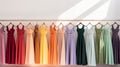 different colored floor-length dresses hang on a hanger on a white background