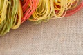 Different colored Italian pasta on the kitchen textiles, close up, top view. With place for your text, for background Royalty Free Stock Photo