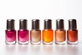 Different colored nail polish bottles in a row on white background Royalty Free Stock Photo