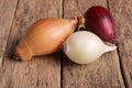 Different colored onions on an old wooden board Royalty Free Stock Photo