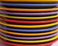 Different colored plates stacked. Dishes in red, orange, yellow, blue, purple and green. Rainbow colors and LGBT