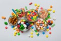 different colored round candy in bowl and jars. Top view of large variety sweets and candies with copy space Royalty Free Stock Photo