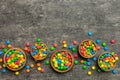 different colored round candy in bowl and jars. Top view of large variety sweets and candies with copy space Royalty Free Stock Photo