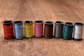 Different Colored Spools Lined up on Wood Royalty Free Stock Photo