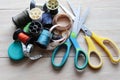 Ã Â¹â¡Different colored spools thread with needles, scissors, and tape measurement isolated on wooden background closeup. Royalty Free Stock Photo