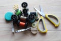 Ã Â¹â¡Different colored spools thread with needles, scissors, and tape measurement isolated on wooden background closeup. Royalty Free Stock Photo