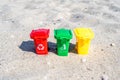 Different colored trash cans with paper, plastic, glass and organic waste suitable for recycling on sandy beach. Segregate waste