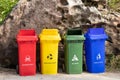 Different colored trash containers for garbage separation with sign and icon near the beach for tourist