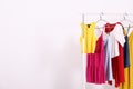 Different colorful casual clothing hanging in row