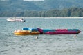 Different colorful inflatable boats for playful beach sport in water by blue sea, anchored at tropical sea, close up photo