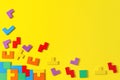 Different colorful shapes wooden puzzle blocks on yellow background. Geometric shapes in different colors, top view Royalty Free Stock Photo