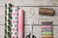 Different colorful wrapping paper rolls, scissors and threads on white wooden table, flat lay Royalty Free Stock Photo