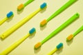 Different colors kids toothbrushes, green and yellow on a yellow background Royalty Free Stock Photo