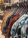 Different coloured shirts hanged on a hanger of a cloth store