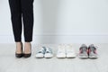 Different comfortable sneakers near businesswoman wearing high heel shoes indoors, closeup Royalty Free Stock Photo