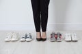 Different comfortable sneakers near businesswoman wearing high heel shoes indoors, closeup Royalty Free Stock Photo