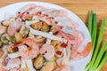 Different cooked seafoods on white dish, fragment close-up