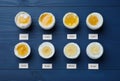 Different cooking time and readiness stages of boiled chicken eggs on blue wooden table, flat lay Royalty Free Stock Photo