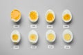 Different cooking time and readiness stages of boiled chicken eggs on light grey background, flat lay Royalty Free Stock Photo
