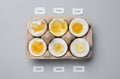 Different cooking time and readiness stages of boiled chicken eggs on light grey background, flat lay Royalty Free Stock Photo