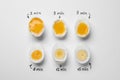 Different cooking time and readiness stages of boiled chicken eggs on white background, flat lay Royalty Free Stock Photo