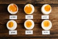 Different cooking time and readiness stages of boiled chicken eggs on wooden table Royalty Free Stock Photo