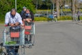 Different customers in line for grocery shopping, men wearing face protection mask lay on their shopping carts