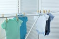 Different cute baby onesies hanging on clothes line . Laundry day Royalty Free Stock Photo