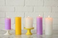 Different decorative wax candles on table