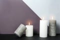 Different decorative wax candles on table