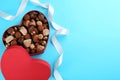 Different chocolate candies in heart shaped box and ri Royalty Free Stock Photo