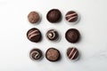 Different delicious chocolate truffles on white marble table, flat lay Royalty Free Stock Photo