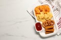 Different delicious fast food served with ketchup on white marble table, top view. Space for text Royalty Free Stock Photo