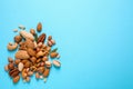 Different delicious nuts on blue background, flat lay. Space for text