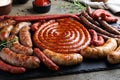 Different delicious sausages with rosemary and sauces on wooden table, closeup. Assortment of beer snacks Royalty Free Stock Photo