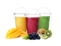 Different delicious smoothies in plastic cups on background Royalty Free Stock Photo