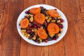 Different dried fruits and berries on dish on rustic table