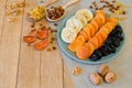 Different dried fruits on a plate on a wooden table Royalty Free Stock Photo