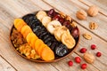 Different dried fruits on a plate on a wooden table Royalty Free Stock Photo