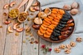 Different dried fruits on a plate on a wooden table Royalty Free Stock Photo