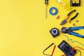 Different electrician`s supplies on yellow background. Background of professional electrician tools with space for text Royalty Free Stock Photo