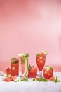 Different elegant glasses with watermelon cocktail. Splash, splatter, water drops on the pink background