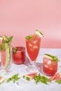 Different elegant glasses with watermelon cocktail. Splash, splatter, water drops on the pink background