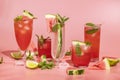 Different elegant glasses with watermelon cocktail. Splash, splatter, water drops on the pink background with sun light