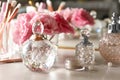 Different elegant perfume bottles on table