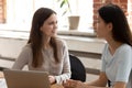 Different ethnicity schoolmates do common task seated at classroom desk